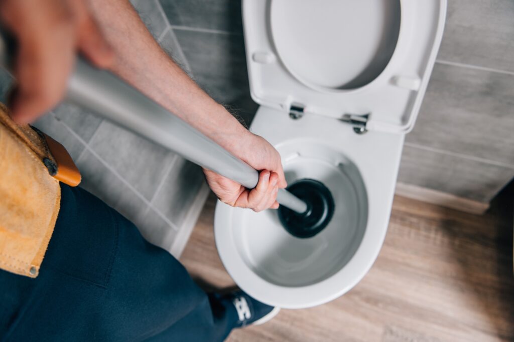 Plumber Cleaning a Clogged Toilet